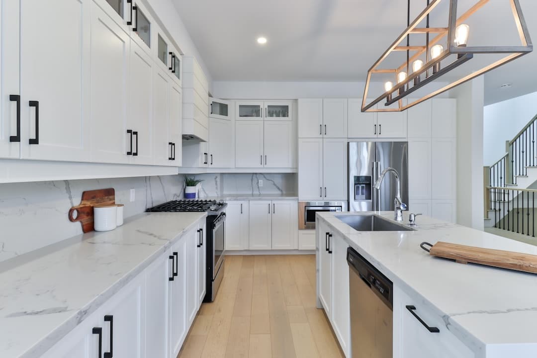Kitchen with freshly refinished white cabinetry and warm wooden floors