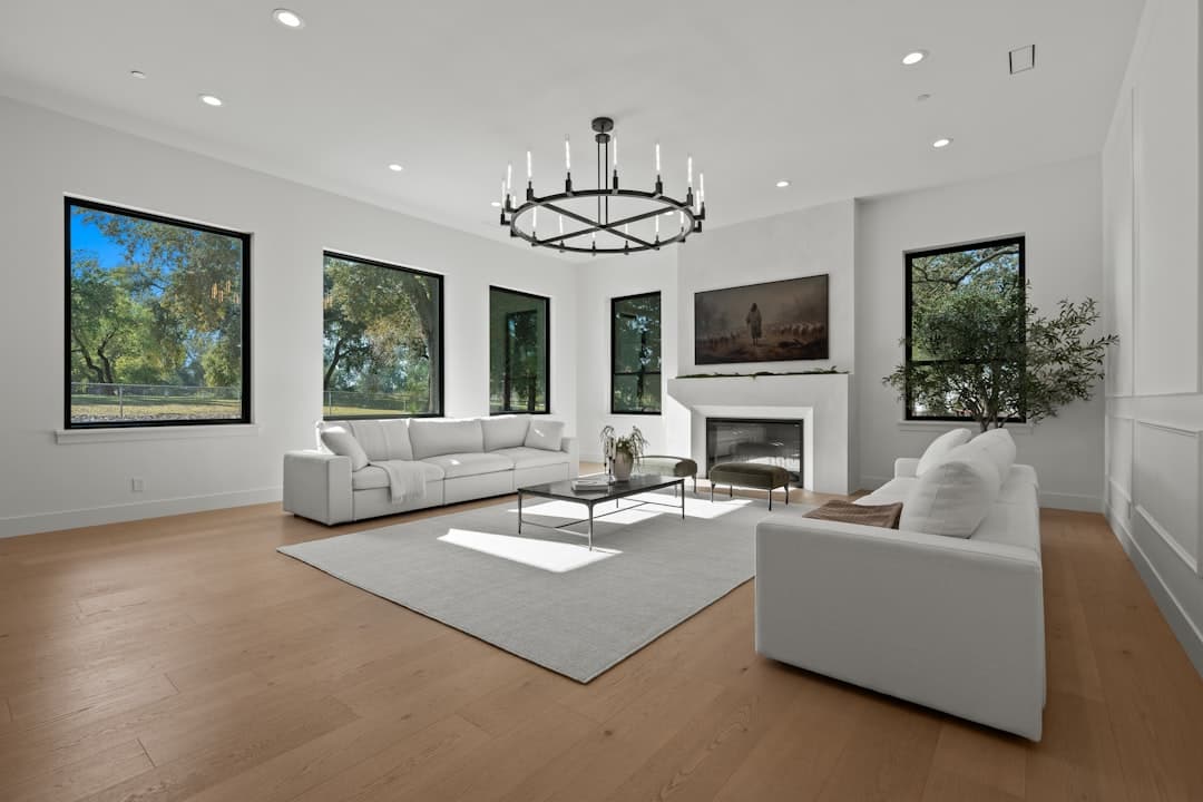 Spacious modern living room with white sofas, fireplace, and flawless wall finish