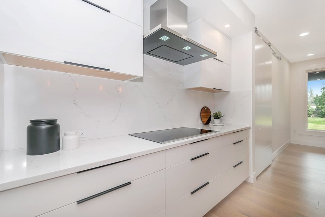 Luxury kitchen with professionally refinished white cabinets and elegant hardware